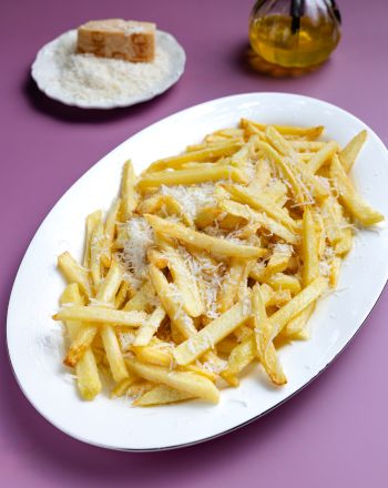 Χρυσαφένεις τηγανητές πατάτες με παρμεζάνα που λιώνει και λάδι τρούφας