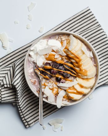 Overnight oats με μπανάνα, μούρα, νιφάδες καρύδας, σοκολάτα και βούτυρο ξηρών καρπών