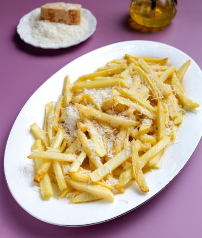 Χρυσαφένεις τηγανητές πατάτες με παρμεζάνα που λιώνει και λάδι τρούφας